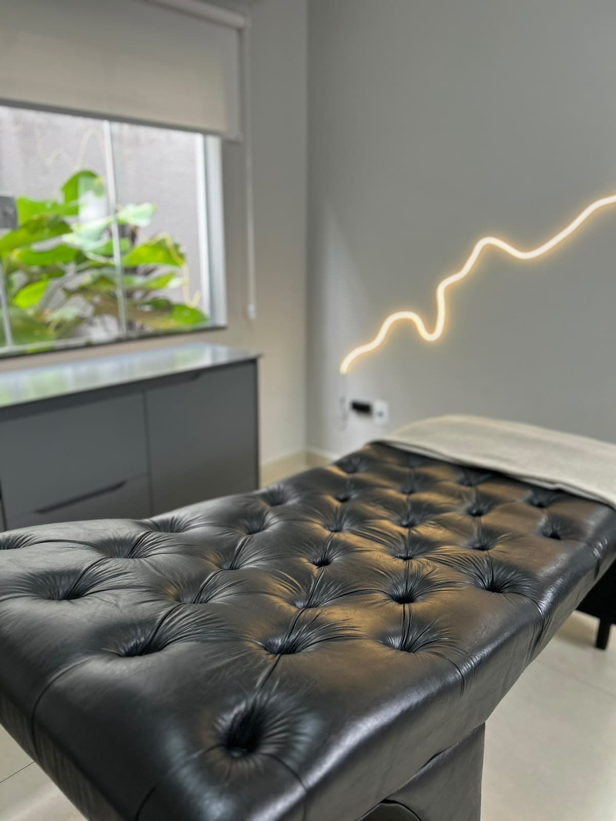 Sala de atendimento, com maca e janela